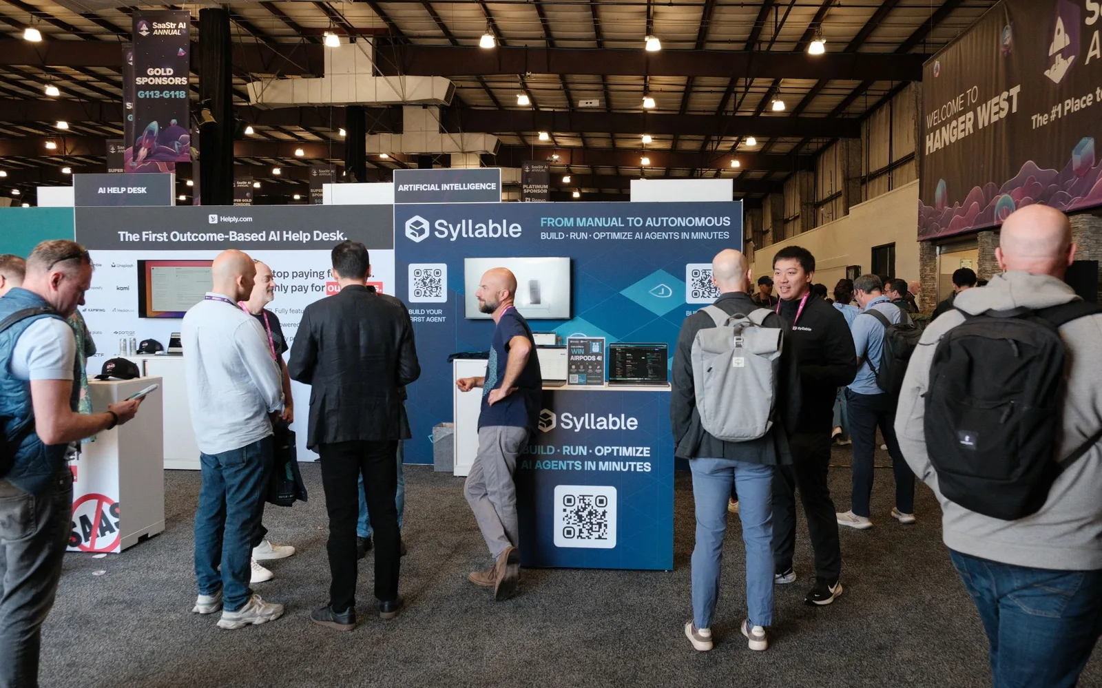 Attendees gathered around the Syllable AI booth talking with team members and watching live demos