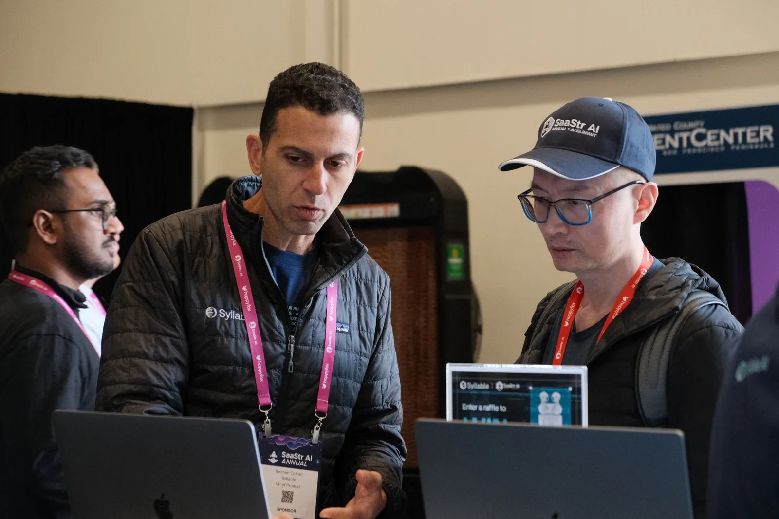 Two Syllable AI team members in a laptop deep-dive with an attendee at the booth